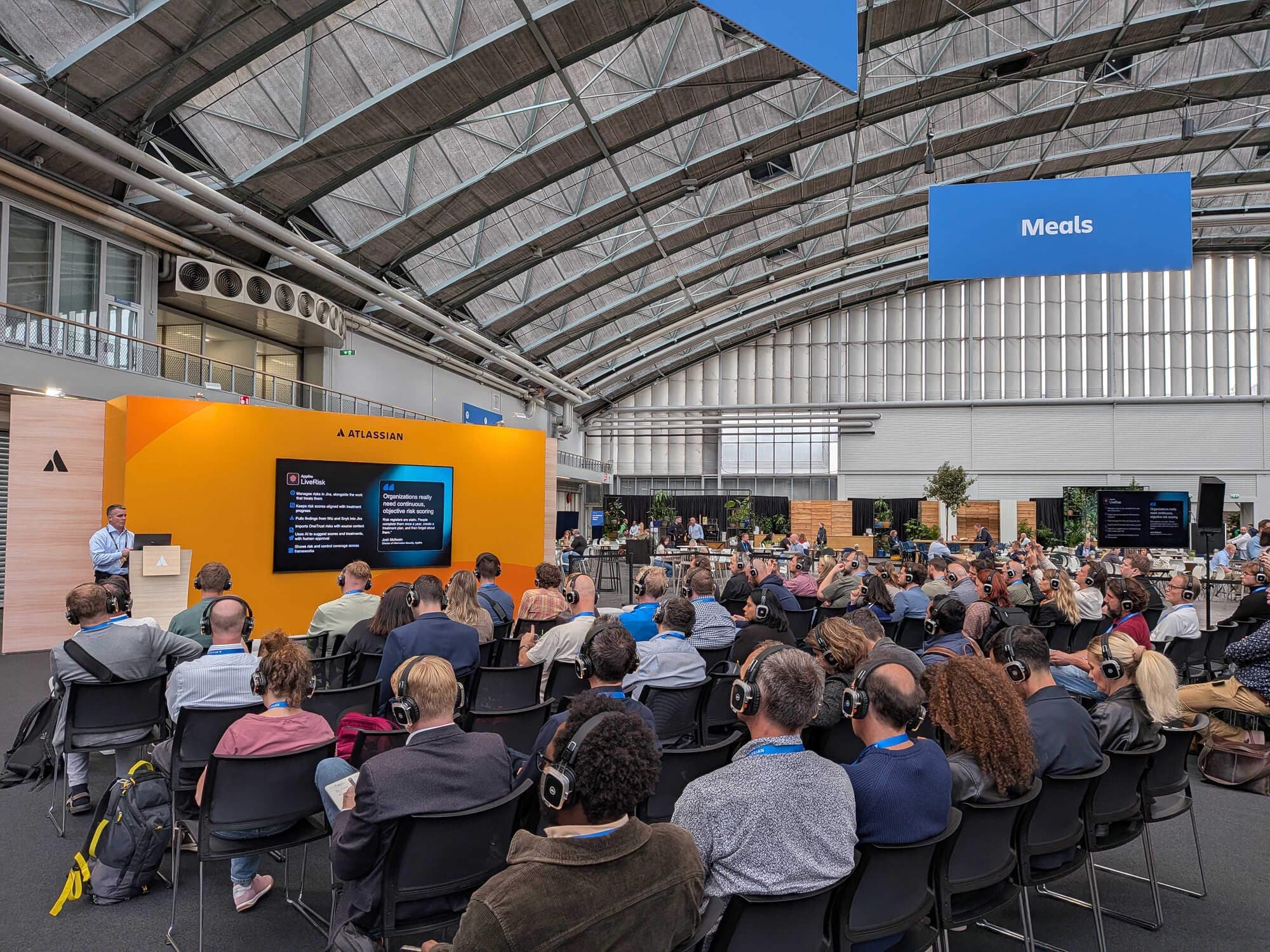 Attendees watching an Atlassian presentation featuring Appfire LiveRisk at Team '26 Europe.