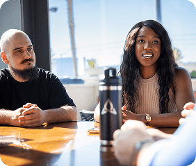 Team engaged in a collaborative meeting at a sunlit table, discussing project strategy.