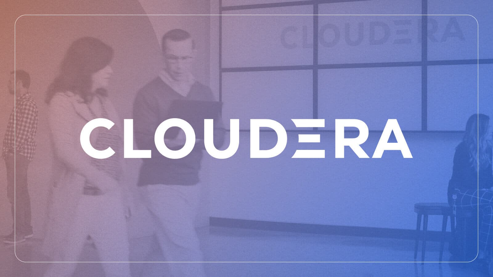 “Cloudera” logo overlaid a candid still of two people walking together in an office, looking at an open laptop together.