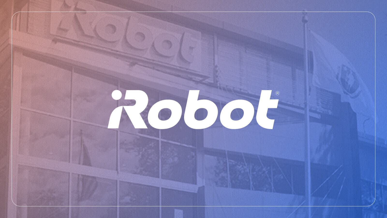 Front of the iRobot building with a flag blowing in the wind to the right and the company’s "iRobot" logo atop image.